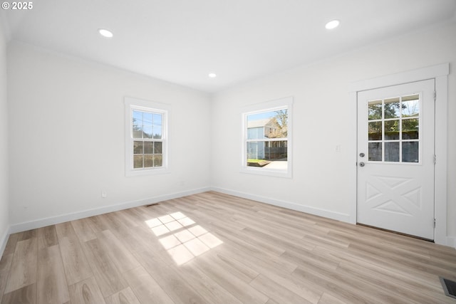 unfurnished room featuring plenty of natural light and light wood finished floors