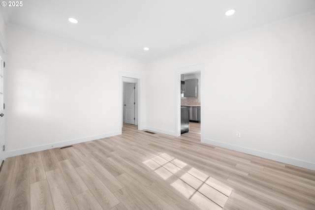 unfurnished room featuring light wood finished floors, visible vents, baseboards, ornamental molding, and recessed lighting