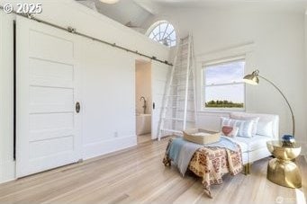 53139 Appleton Rd, Milton-Freewater, OR 97862 - bedroom with wood finished floors, a barn door, multiple windows, and lofted ceiling