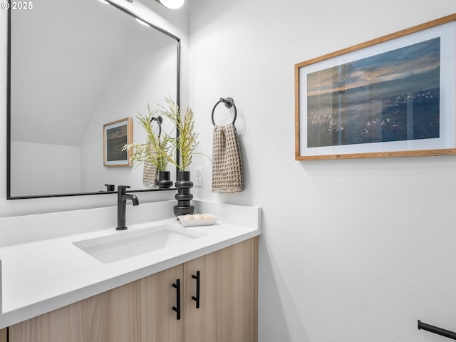 bathroom with vanity and lofted ceiling
