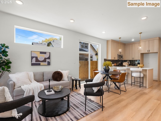 living room with a wealth of natural light, recessed lighting, and light wood-type flooring