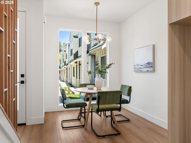 dining room with baseboards, a chandelier, and wood finished floors