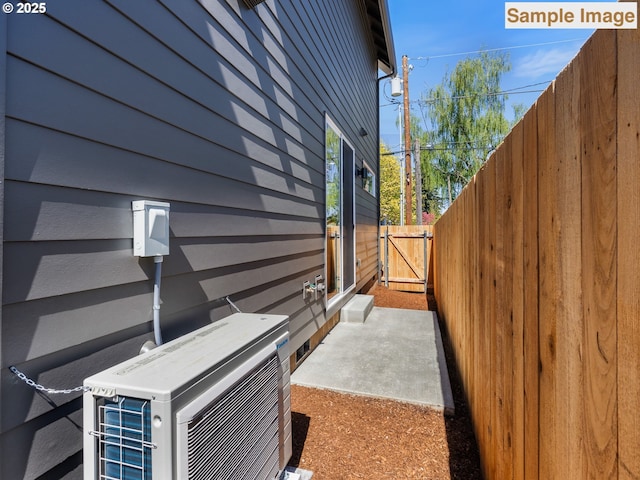 view of home's exterior with a patio, fence, ac unit, and a gate