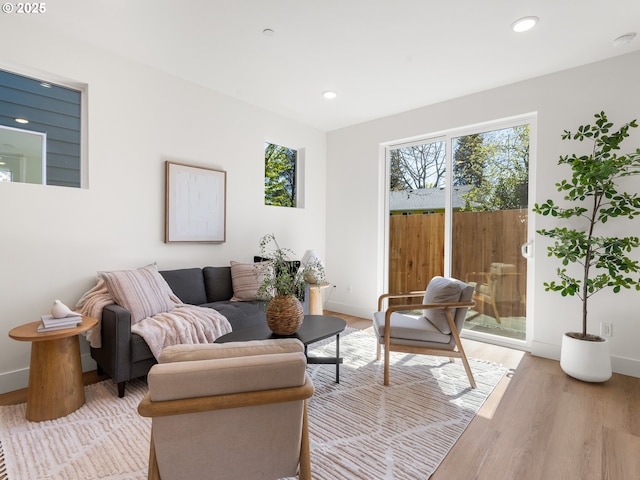 living area with baseboards, recessed lighting, and light wood-style floors