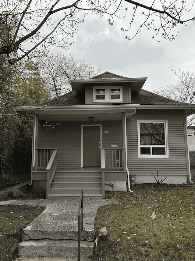 view of front of home featuring a shingled roof and a porch