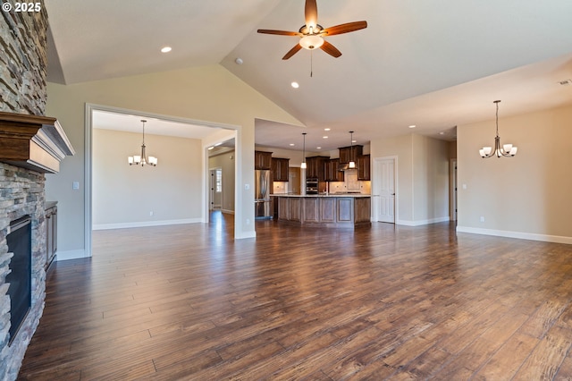unfurnished living room with a chandelier, a stone fireplace, ceiling fan, dark wood-type flooring, and recessed lighting