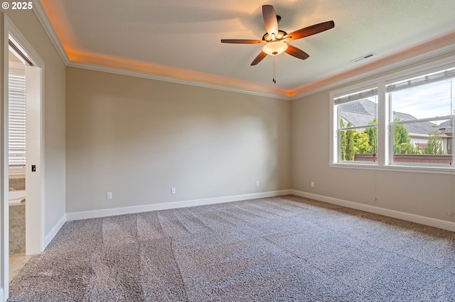 unfurnished room featuring carpet, ornamental molding, a ceiling fan, and baseboards