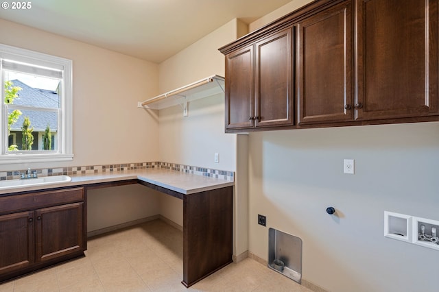 washroom featuring cabinet space, hookup for a washing machine, a desk, and light tile patterned floors