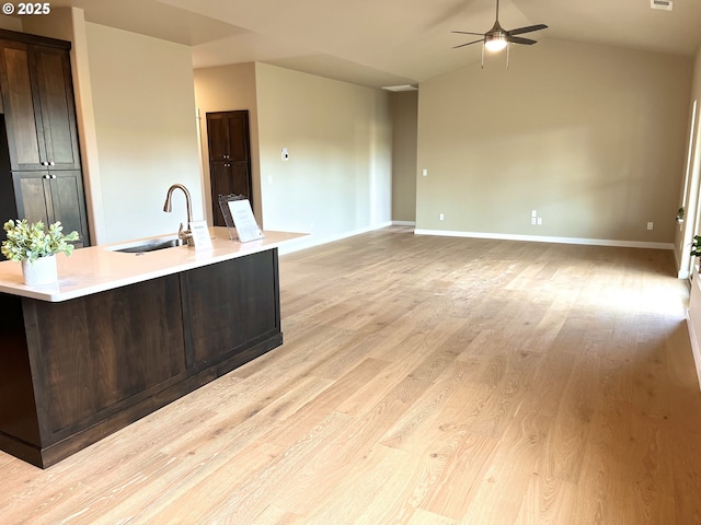 947 Medina Ave, Sutherlin, OR 97479 - kitchen featuring ceiling fan, dark brown cabinetry, light wood-style flooring, a sink, and light countertops