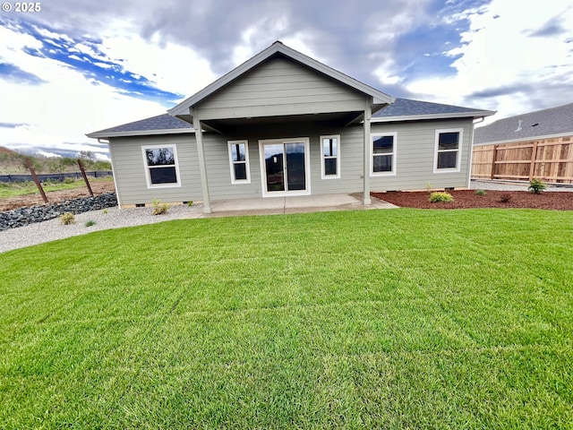 947 Medina Ave, Sutherlin, OR 97479 - rear view of house with roof with shingles, crawl space, a patio area, fence, and a lawn