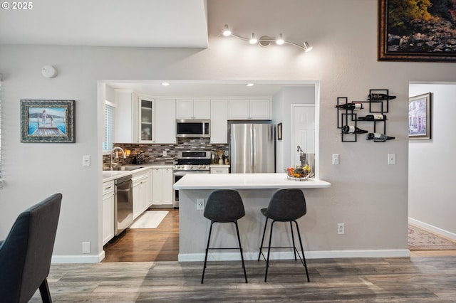 17622 NW Rolling Hill Ln, Beaverton, OR 97006 - kitchen featuring stainless steel appliances, a breakfast bar area, dark wood-style floors, and a peninsula