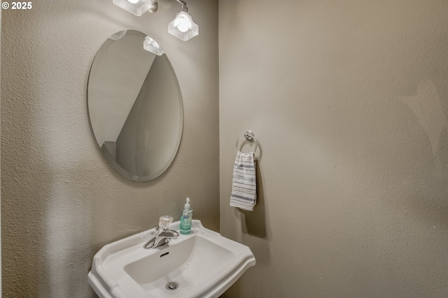 bathroom with a textured wall and a sink