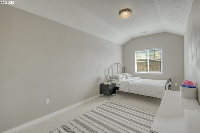carpeted bedroom with lofted ceiling, a textured ceiling, and baseboards