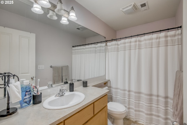 bathroom featuring toilet, visible vents, and vanity