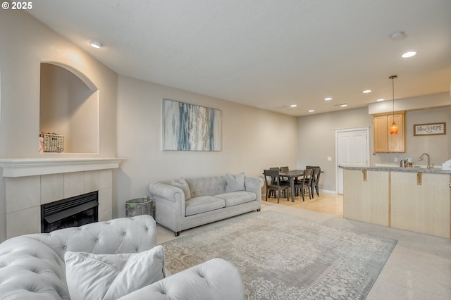 living room featuring recessed lighting, light carpet, and a fireplace