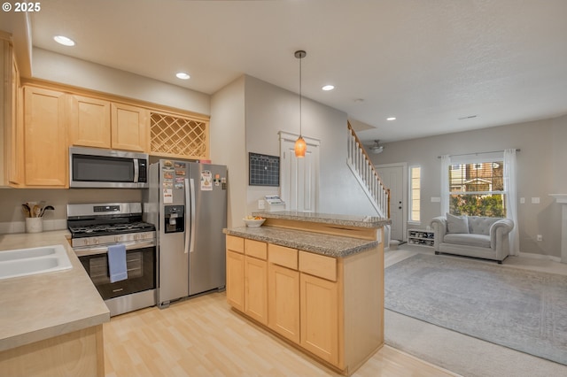 kitchen with open floor plan, stainless steel appliances, light countertops, light brown cabinetry, and recessed lighting