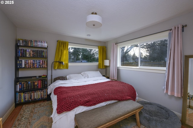 bedroom with dark hardwood / wood-style flooring and a textured ceiling