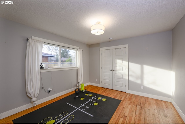 workout room with hardwood / wood-style flooring and a textured ceiling