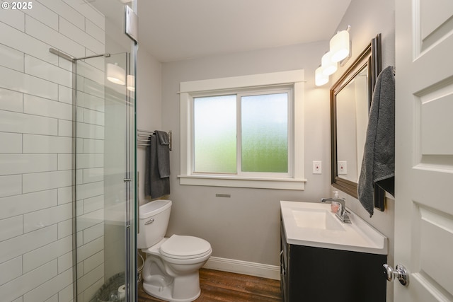 bathroom featuring vanity, an enclosed shower, wood-type flooring, and toilet