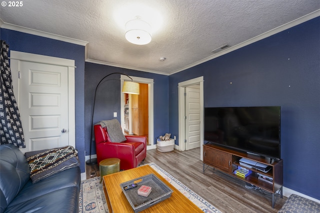 living room featuring crown molding, wood-type flooring, and a textured ceiling