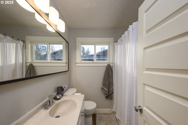 bathroom featuring vanity, a textured ceiling, and toilet