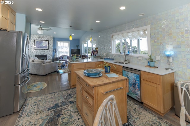 kitchen with freestanding refrigerator, dishwashing machine, butcher block counters, a sink, and open floor plan