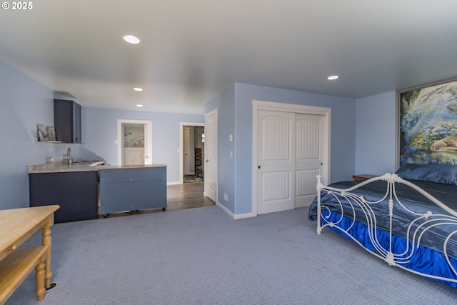 carpeted bedroom with a closet, wet bar, baseboards, and recessed lighting