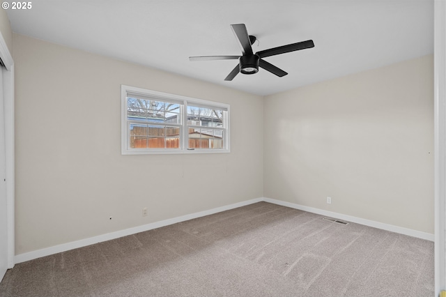 carpeted spare room featuring ceiling fan