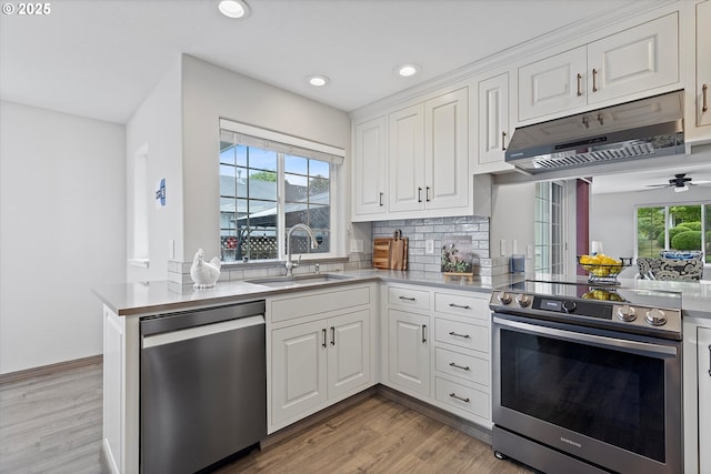 1012 E Foothills Dr, Newberg, OR 97132 - kitchen with appliances with stainless steel finishes, under cabinet range hood, recessed lighting, white cabinets, and light wood finished floors