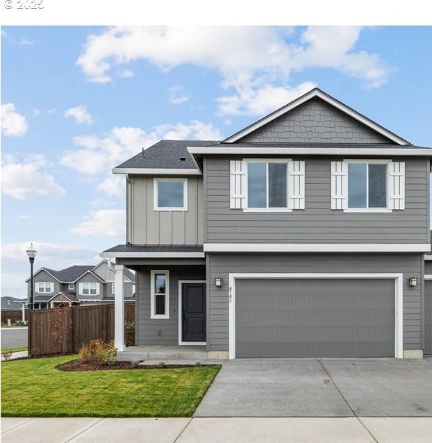 view of front of property featuring concrete driveway, covered porch, an attached garage, fence, and a front yard