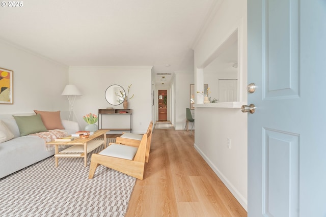 living room featuring baseboards, light wood-style floors, and ornamental molding