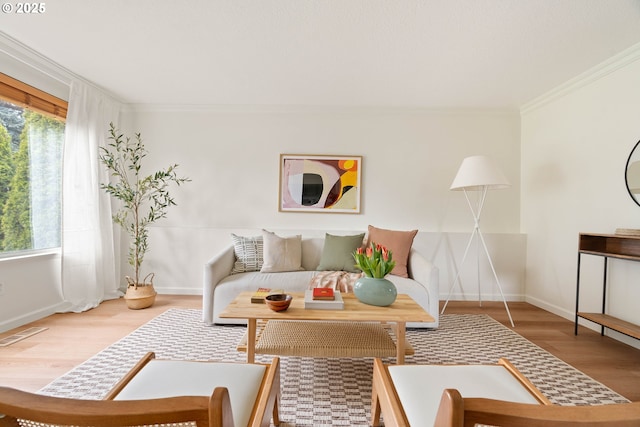 living area featuring wood finished floors, a healthy amount of sunlight, visible vents, and ornamental molding