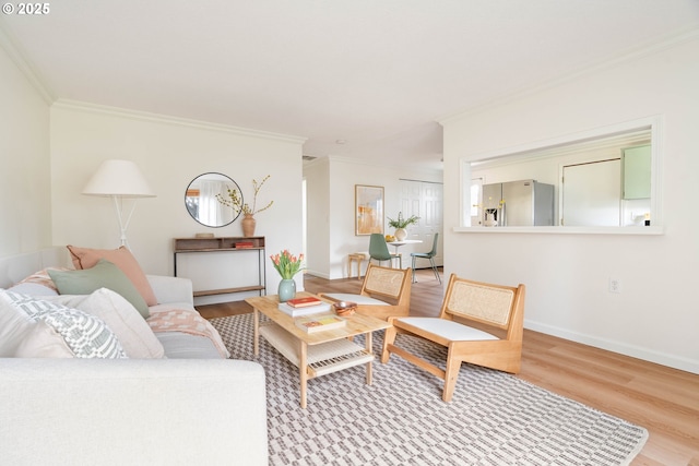 living area featuring crown molding, baseboards, and wood finished floors