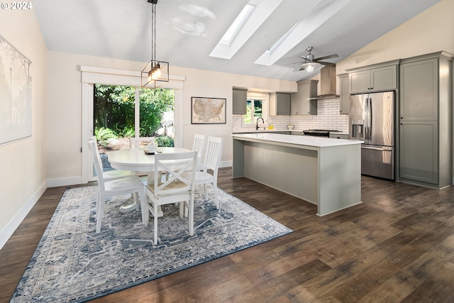 9636 SW Boones Ferry Rd, Portland, OR 97219 - kitchen featuring stainless steel fridge, lofted ceiling, wall chimney range hood, gray cabinets, and a skylight