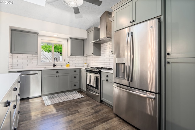 9636 SW Boones Ferry Rd, Portland, OR 97219 - kitchen with stainless steel appliances, gray cabinets, a sink, wall chimney range hood, and dark wood finished floors