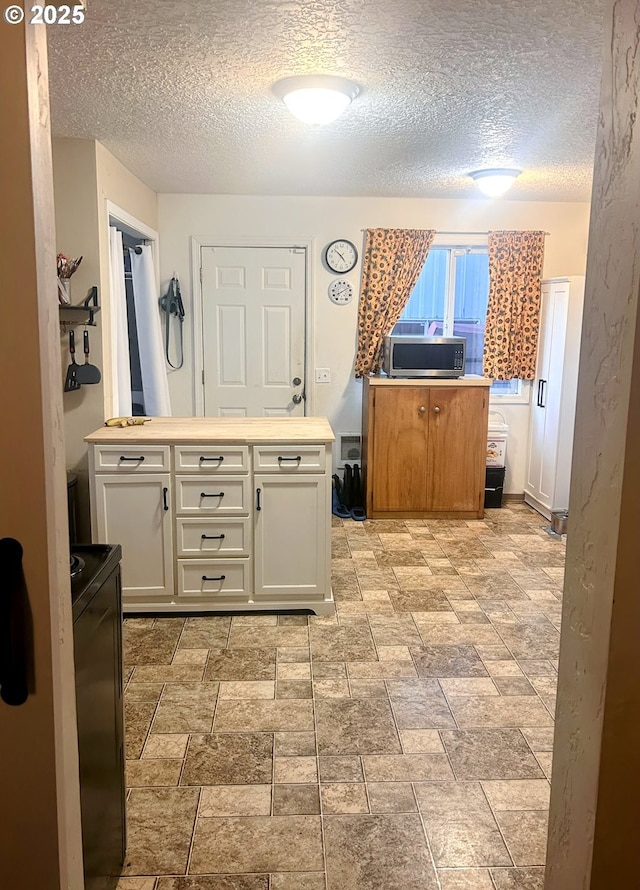 kitchen featuring white cabinetry and a textured ceiling