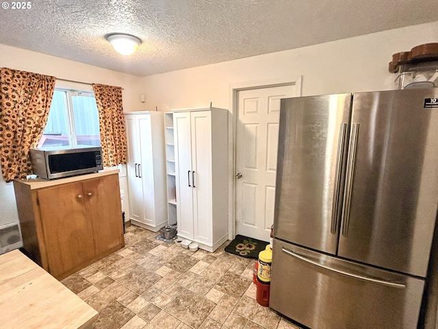 kitchen featuring appliances with stainless steel finishes and a textured ceiling