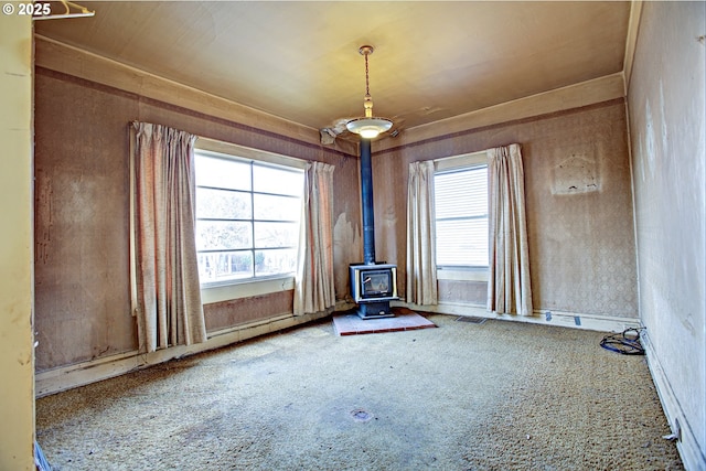 carpeted spare room with a wood stove