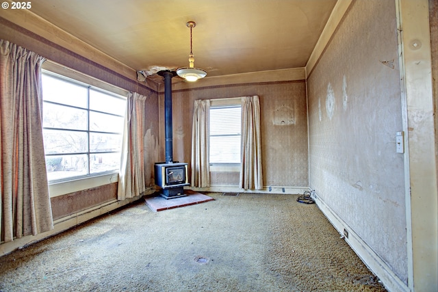 spare room featuring plenty of natural light and a wood stove