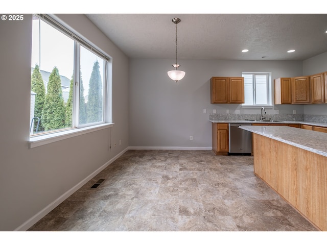 kitchen featuring visible vents, dishwasher, decorative light fixtures, light countertops, and a sink