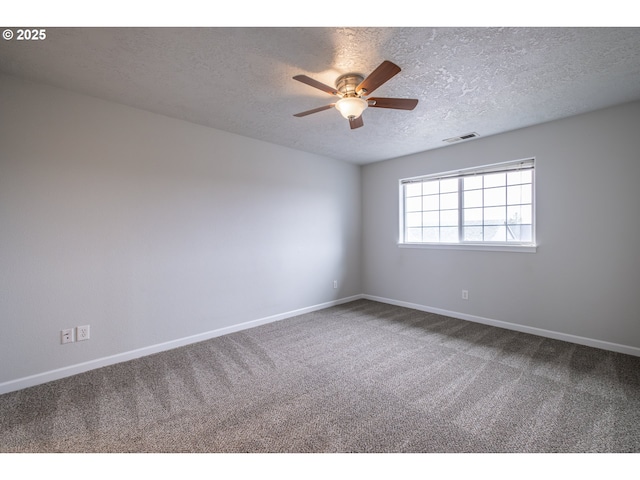 carpeted spare room featuring a ceiling fan, visible vents, a textured ceiling, and baseboards