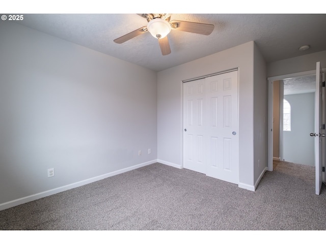 unfurnished bedroom with carpet floors, a closet, baseboards, and a textured ceiling