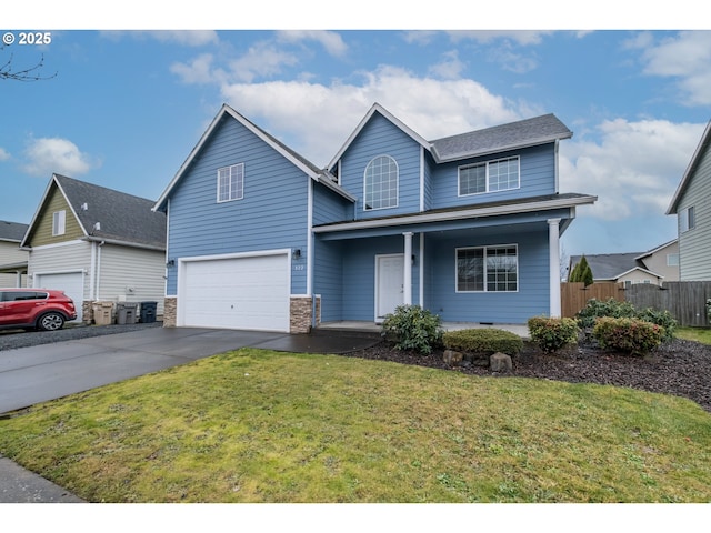 traditional-style house with an attached garage, covered porch, fence, driveway, and a front yard