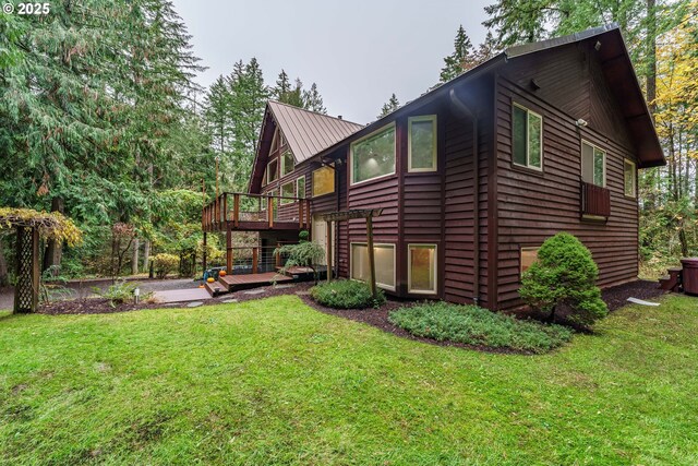 back of house featuring a wooden deck and a yard