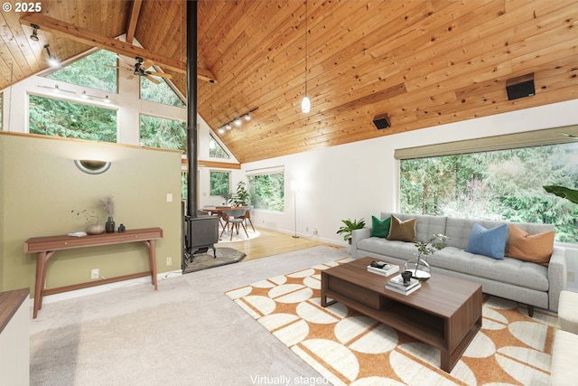 carpeted living room with wood ceiling, ceiling fan, high vaulted ceiling, and a wood stove