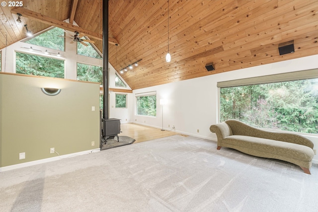 living area with carpet flooring, high vaulted ceiling, wooden ceiling, and a wood stove