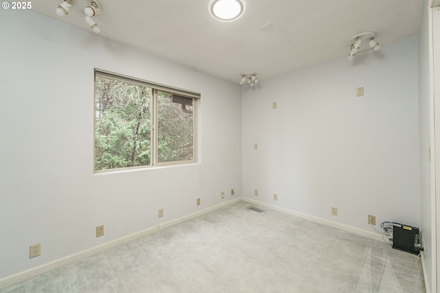 spare room featuring light colored carpet