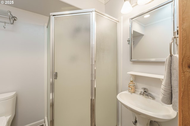 bathroom with sink, crown molding, toilet, and walk in shower