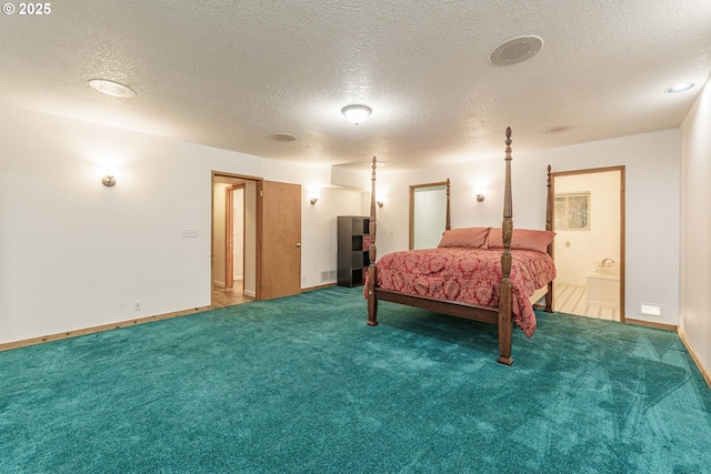 carpeted bedroom with ensuite bathroom and a textured ceiling