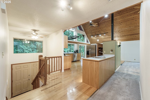 kitchen featuring wood ceiling, stainless steel appliances, vaulted ceiling, and a textured ceiling